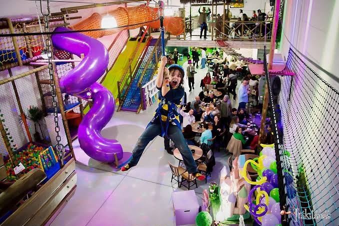 Criança voando de tirolesa em festa no Jack Kingdom