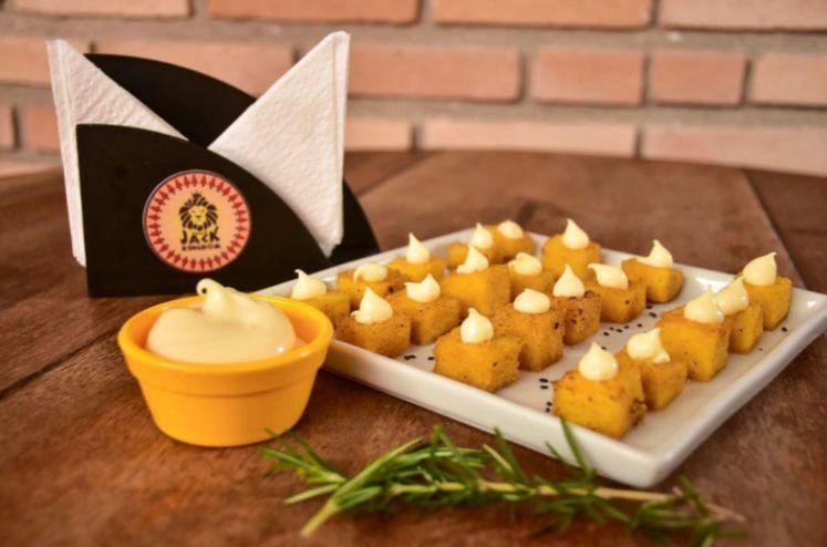 Polenta frita com molho, guardanapeiro com a logo Jack Kingdom